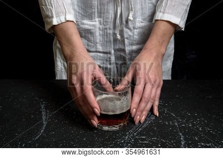Woman Hand Holdin A Glass With Dark Beer On Black Background