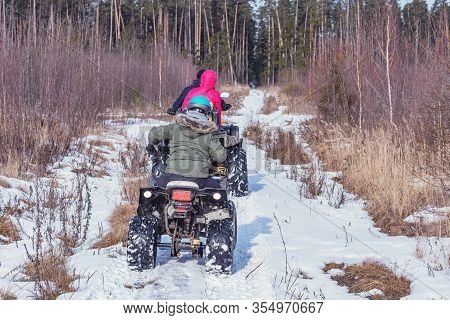 Family On The Atv Quad Bikes On The Winter Road.