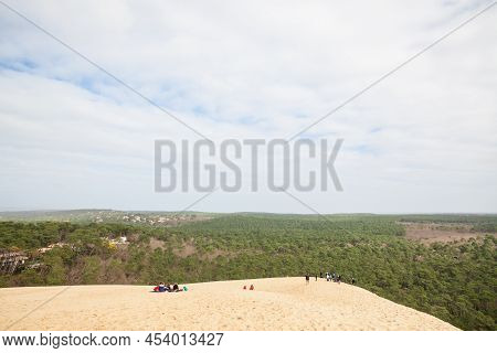 Pilat, France - February 22, 2022: Group Of Tourists Climbing In Crowd The Sandy Slopes Of The Pilat