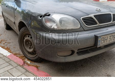 Сar Was Damaged By Shells And Bullets In A Parking Lot. Damaged Sedan During Shelling. Russia's Atta