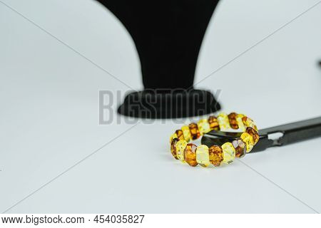 An Amber Bracelet, A Precious Stone, An Ornament Made Of A Precious Stone Lies On The Table