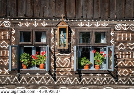 Cicmany, Slovakia - August 25, 2021: Red Flowers In Pot In Windows Of Old Wooden Cottage In Village 
