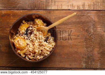 A Plate Of Couscous With Saffron And Nuts On A Wooden Table With A Wooden Spoon. Save A Place. Horiz