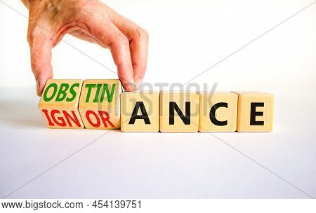 Obstinance Or Ignorance Symbol. Businessman Turns Cubes, Changes The Word Ignorance To Obstinance. B
