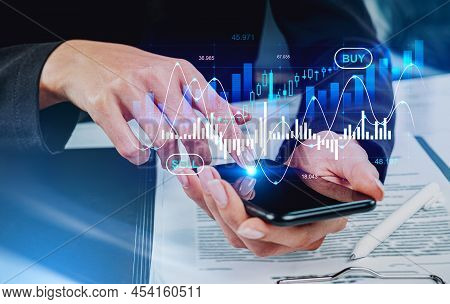 Businesswoman Finger Touch Smartphone Screen, Stock Market Lines And Financial Contract On Table. Hu