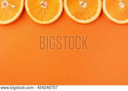 Top View Of Orange Slices With Pits On Orange Background