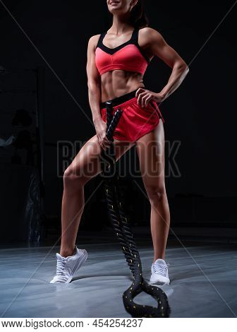 Athletic Woman In Red Shorts And Top Exercising With Ropes In Functional Training Area. Fitness Conc