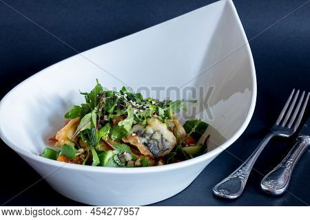 Fried Eggplant In Sweet Sour Sauce With Tomatoes And Cilantro On Blue Plate On Dark Table