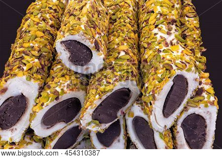 Nuga With Chocolate-filled Pistachio Seeds On A Black Background Up Close
