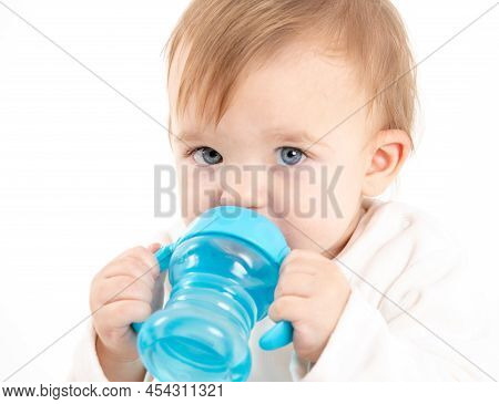 Stock Studio Photo With A White Background Of A Baby Drinking Water From A Canteen With Handles.