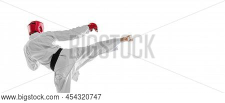Back View. Portrait Of Young Sportive Man Wearing White Dobok, Helmet And Gloves Practicing Isolated