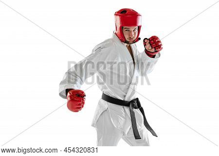 Portrait Of Young Sportive Man Wearing White Dobok, Helmet And Gloves Practicing Isolated Over White