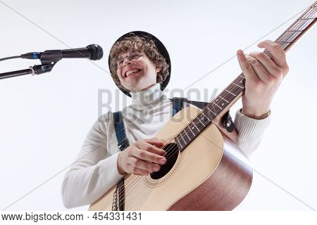 Portrait Of Young Emotiona Man, Musician Playing Acoustic Guitar And Singing. Concept Of Art, Music,