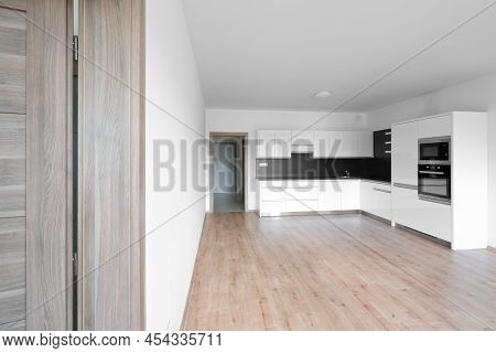 Celadna, Czechia - 05.07.2022: Empty Room With Wooden Floor And White And Black Modern Design Kitche
