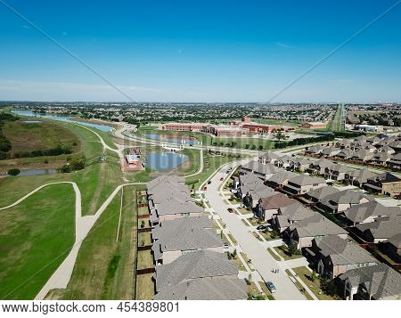 Aerial View Shingle Roof Of Brand New Houses With Compact Backyard And School District In Background