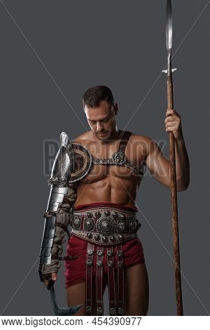 Gladiator Spearman With Muscular Build Against Grey Background