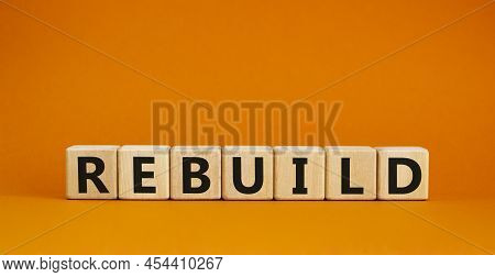 Rebuild And Build Symbol. The Concept Word Rebuild On Wooden Cubes. Beautiful Orange Table, Orange B