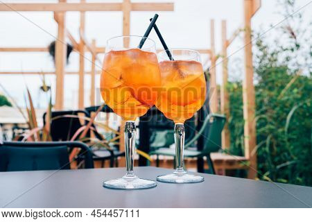 Two Glasses Of Aperol Spritz Served On The Terrace Of Modern Bar. Popular Italian Wine Based Cocktai