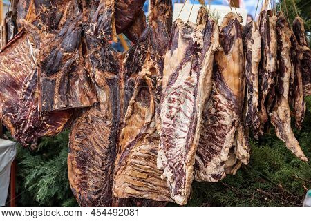 Selective Blur On Blocks Of Pork Meat, Dried Cured Pork, Smoked, Hung On A Stand In The Countryside 