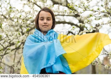 Pray For Ukraine. Child With Ukrainian Flag. Little Girl With The Flag Of Ukraine Waving National Fl