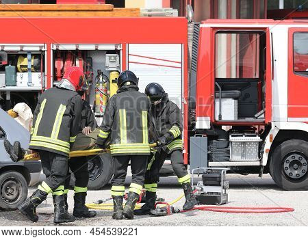 Team Of Firefighters Carrying The Injured Man With The Stretcher After The Traffic Accident On The H