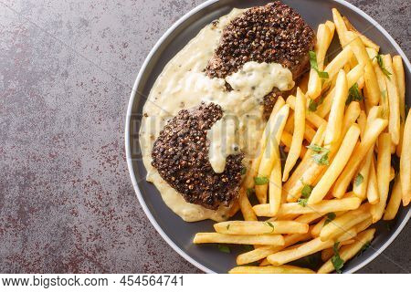 Roasted Steak Au Poivre And Rich Cognac Sauce Served With French Fries Close-up In A Plate On The Ta