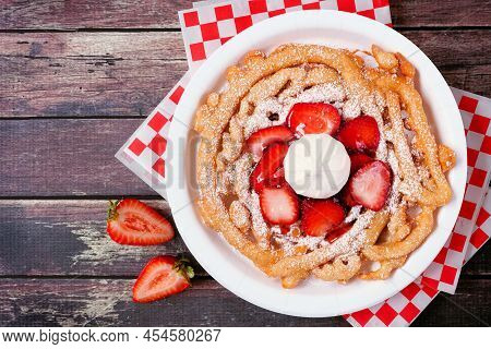 Strawberry Funnel Cake Top View Over A Dark Wood Background. Traditional Summer Carnival Treat.