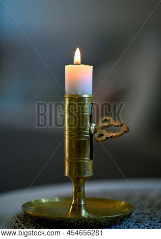 Close To Small Candle In Candlestick Made Of Brass