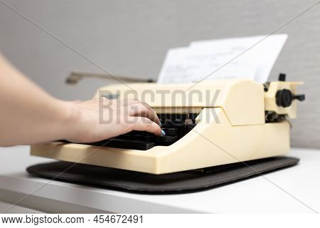 Woman Typing Text On An Old Typewriter. High Quality Photo