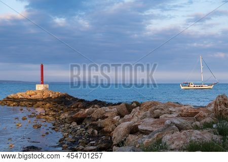 Lighthouse And Sailboat Bathed In Afternoon Light In Potamos Liopetri Fishing Village In The Mediter