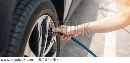 Hand Inflating Tires Of Vehicle, Checking Air Pressure And Filling Air On Car Wheel At Gas Station. 