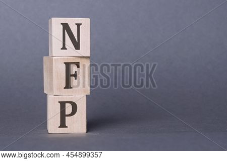 Word Nfp - Nonfarm Payroll On Wooden Cubes With Letters Isolated On Dark Gray Background,