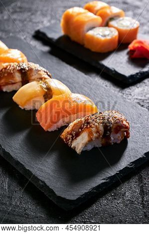 Assorted Sushi With Salmon, Eel And Escolar On Black Stone Plate On Dark Background