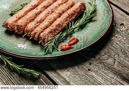 Raw Lula Kebab On Skewers With Spices On A Cutting Board Light Background. Lula Kebab, Traditional C