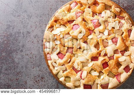 Scandinavian Rhubarb Cake With Almond Flakes Closeup In The Plate On The Table. Horizontal Top View 