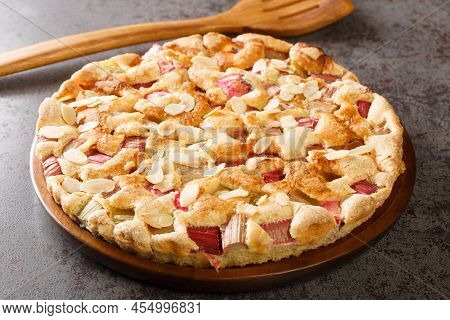 Scandinavian Rhubarb Cake With Almond Flakes Closeup In The Plate On The Table. Horizontal