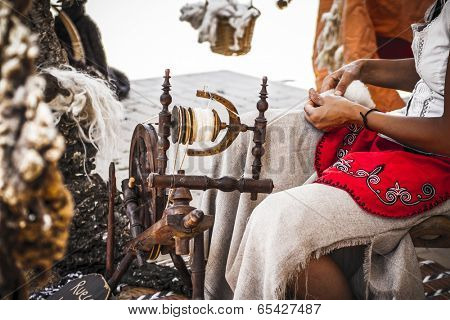 distaff, woman spinning yarn on an old spinning wheel