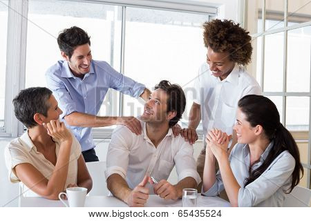 Attractive businessman praising coworker during a meeting