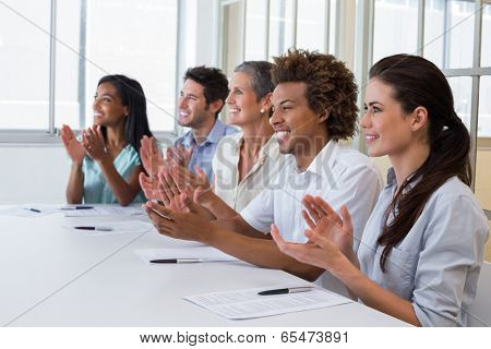 Casual business team clapping at presentation in the office