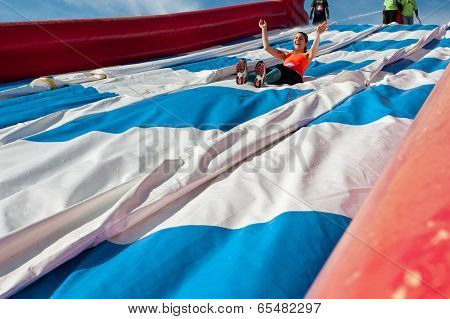 Young Woman Laughs Going Down Slide In Obstacle Race