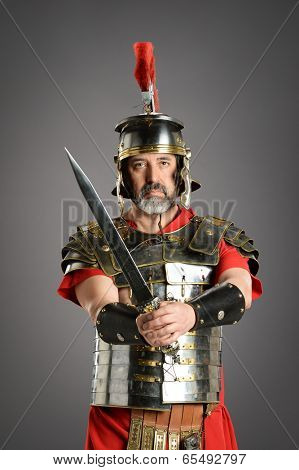 Portrait of Roman centurion holding sword over a neutral background