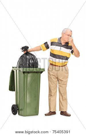 Full length portrait of a senior throwing away a stinky bag of trash isolated on white background