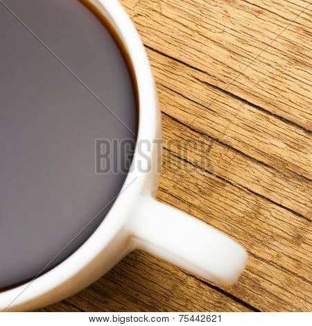 Close Up Of White Ceramic Coffee Cup On Wooden Table - View From Top