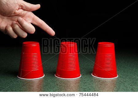 Three Red Cups And A Pointing Hand