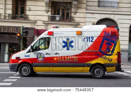 MADRID, SPAIN - OCTOBER 9, 2014: An ambulance speeding through the streets of Madrid. Due to Spanish law, only police use blue lights and ambulances and fire engines have to use amber lights.