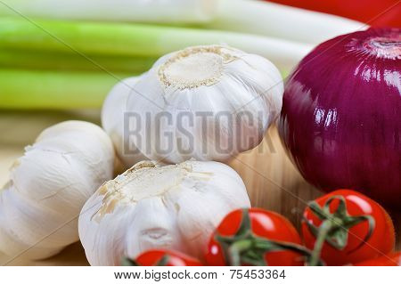 White garlic and purple onion on a wooden board