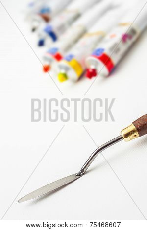 Palette Knife Closeup And Oil Paint Tubes On White Canvas