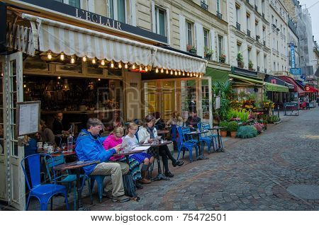 Family examines menu at a bistro in Paris