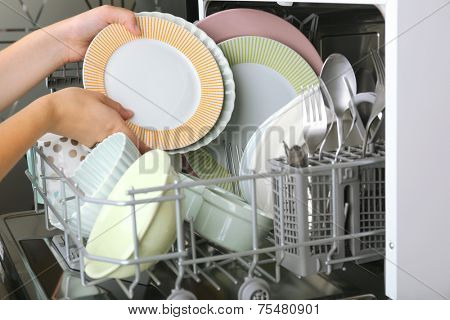Open dishwasher with clean utensils in it