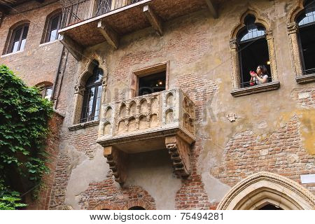 Girl Photographs On Their Smartphone From A Window In The Museum Courtyard Juliet. Verona, Italy